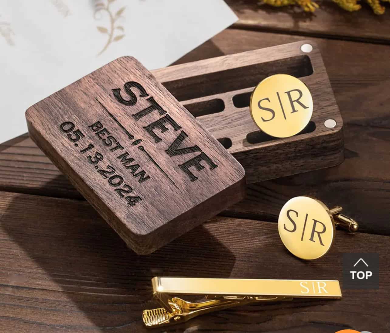 A wooden box engraved with STEVE, BEST MAN, 05.13.2024 sits beside the Personalised Cufflinks and Tie Clip Gift Set, both engraved with S|R, on a wooden surface—an elegant personalised gift for special occasions.