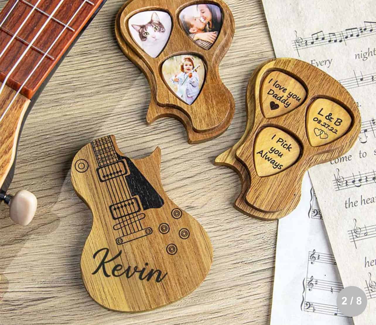 The Personalised Guitar Picks With Case is a wooden, guitar-shaped box engraved with Kevin, opening to reveal three photo slots and three heart-shaped messages: I love you Daddy, I pick you always, and L&B 09.22.