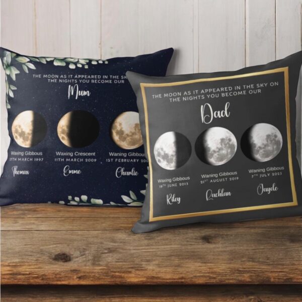 Two personalized pillows show moon phases for Mum and Dad on the nights their children were born, with dates and names listed under each lunar image, set against a rustic wooden background.