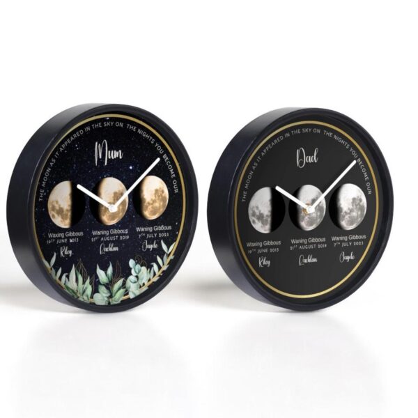 Two round wall clocks display personalized moon phases for “Mum” and “Dad,” with names, dates, and phases labeled beneath moon images. The “Mum” clock has a leafy design, while the “Dad” clock has a plain black background.