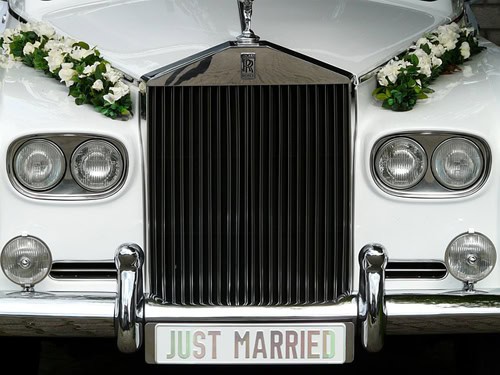 Elegant wedding car with floral decorations and "Just Married" sign for special occasions.