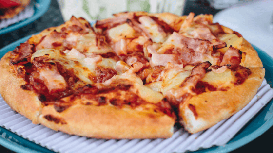 Delicious homemade pizza with ham and pineapple, perfect for catering events.