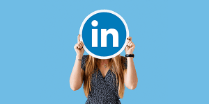 LinkedIn logo held by woman representing professional networking and business growth.
