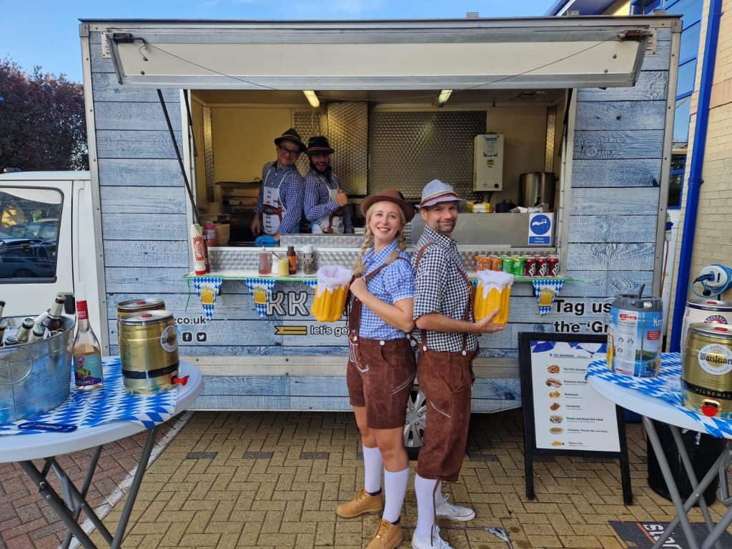 KK Catering team serving German bratwurst at a corporate event.