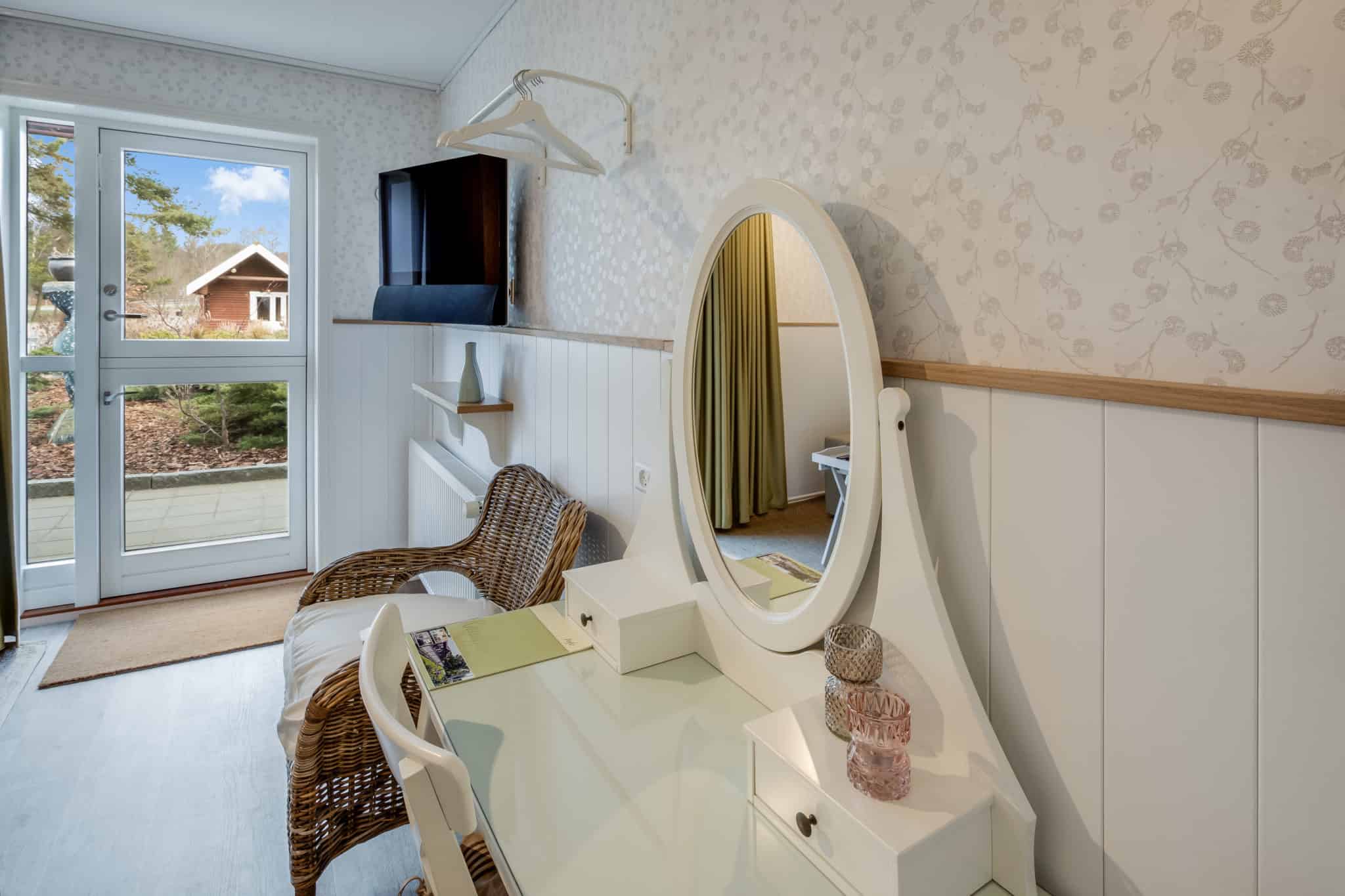 Komfortabel værelse med spejl og balkon ved Knudhule Badehotel.