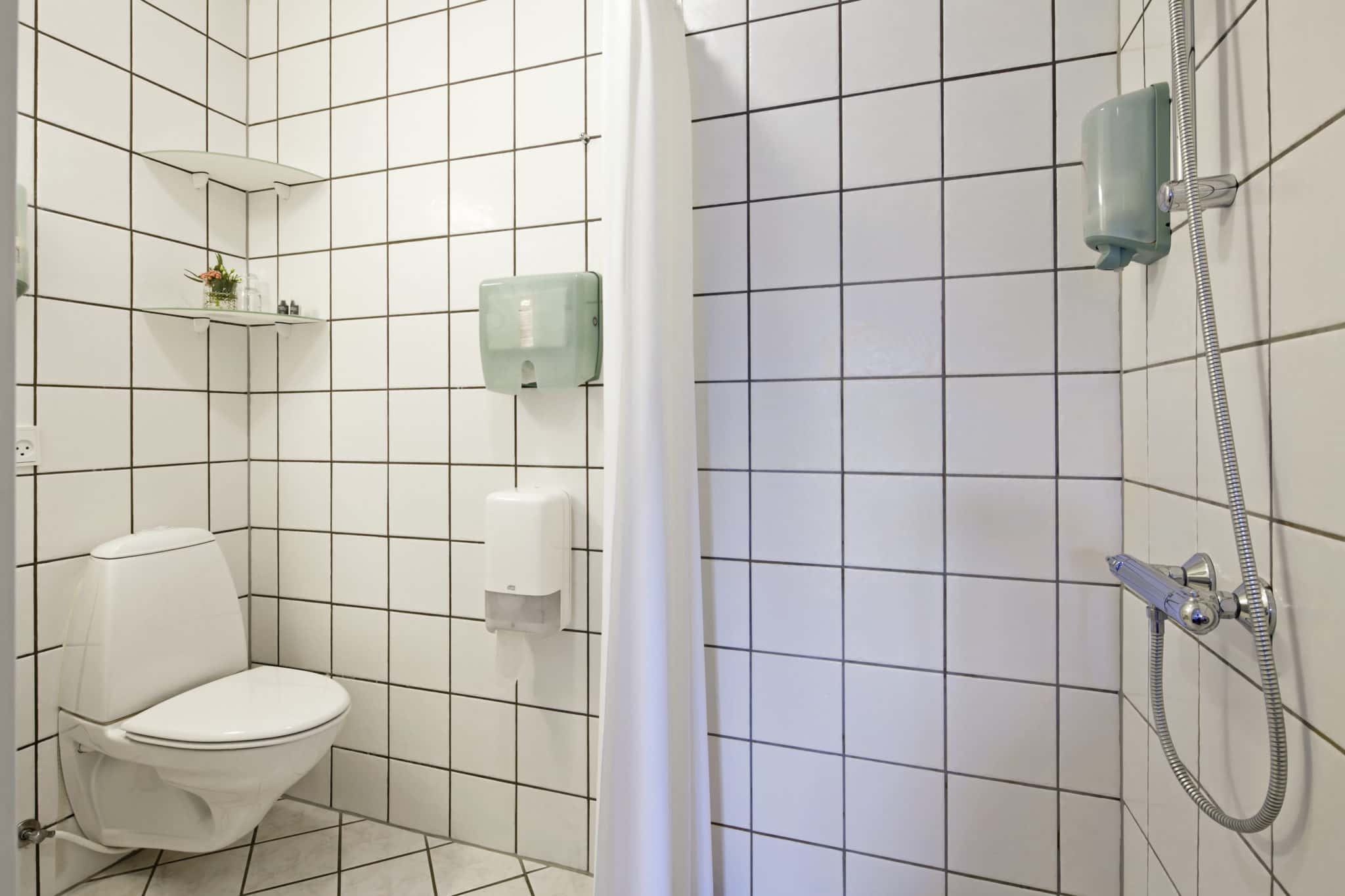 Håndikapvenlig bruser og toilet på Knudhule Badehotel, moderne badefaciliteter.