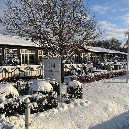 Knskudhule Badehotel i sneet, skøn vinterudsigt med hotelfacade og snedækkede omgivelser.