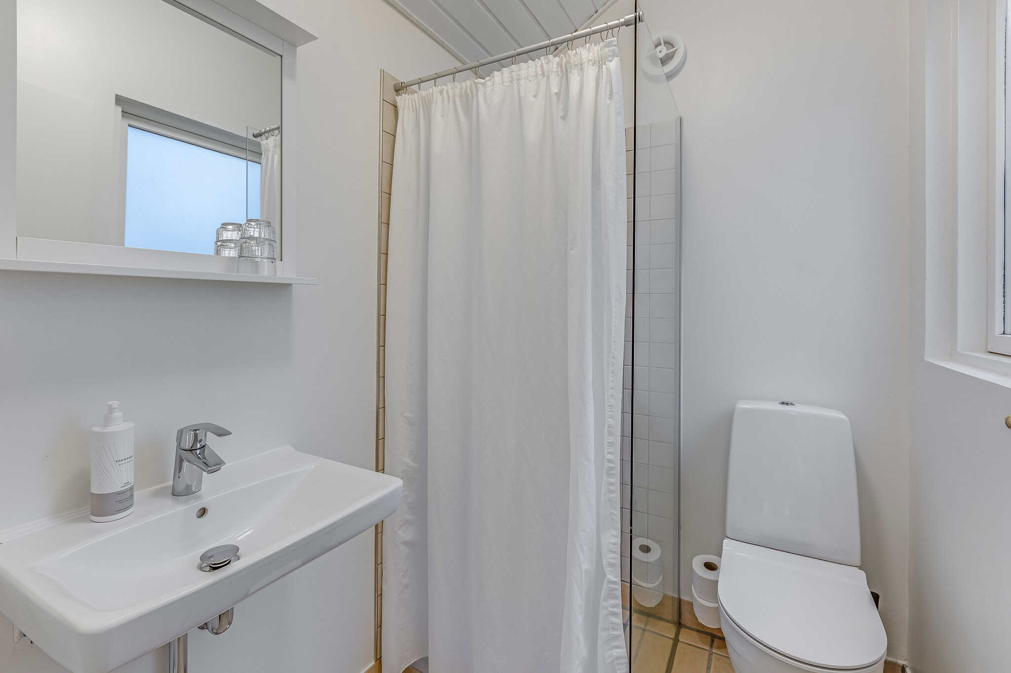 Renoveret badeværelse på Knudhule Badehotel, moderne og ren design med brusebad og toilet.