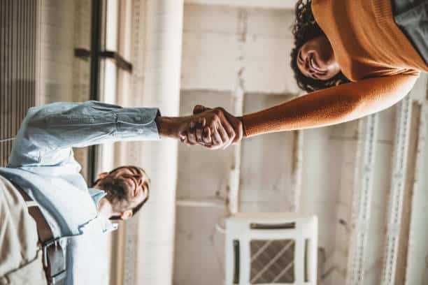 Two Business people shaking hands after Welcoming partners finishing up a meeting or setting goals and planning way to success in the office.