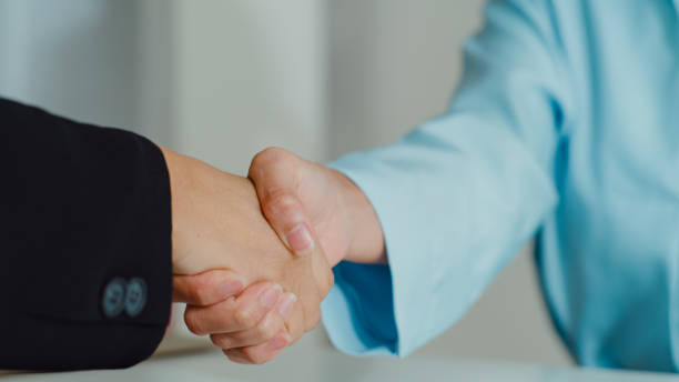 Choosing the Right Lawyer Two individuals shaking hands to negotiate, Choosing Lawyer concept.