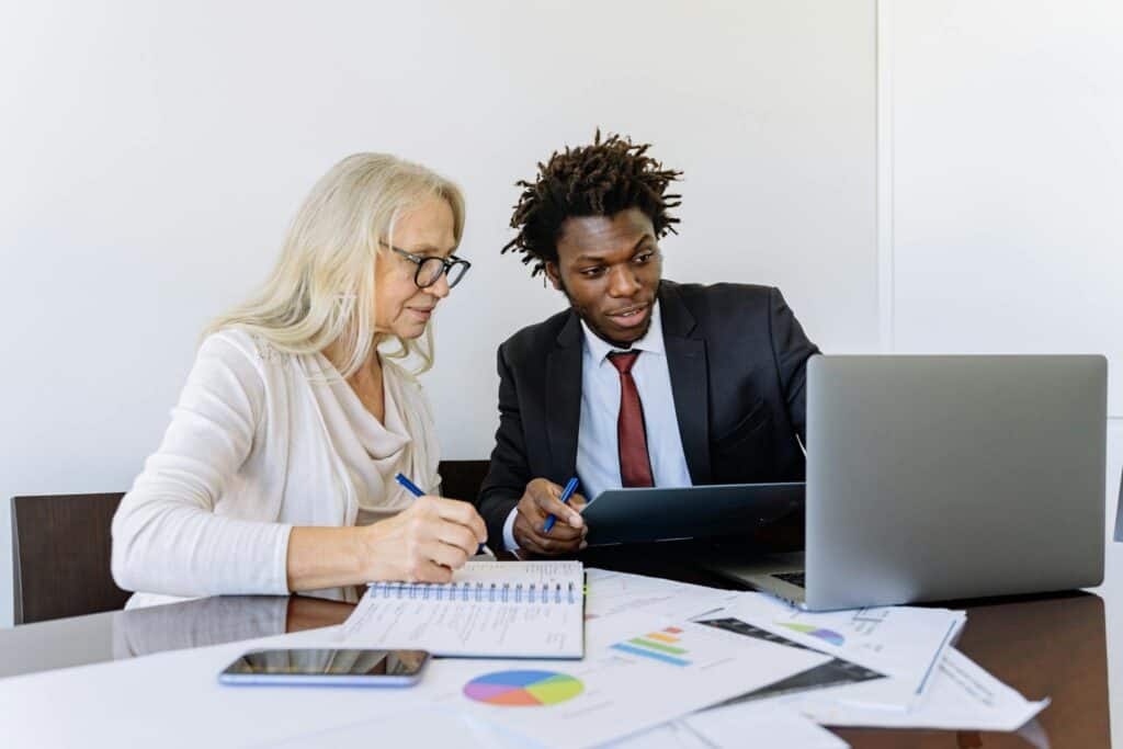 AI Lead Generation for Local Service Businesses 3 Two business professionals collaborating at a desk with laptops and documents in an office setting.