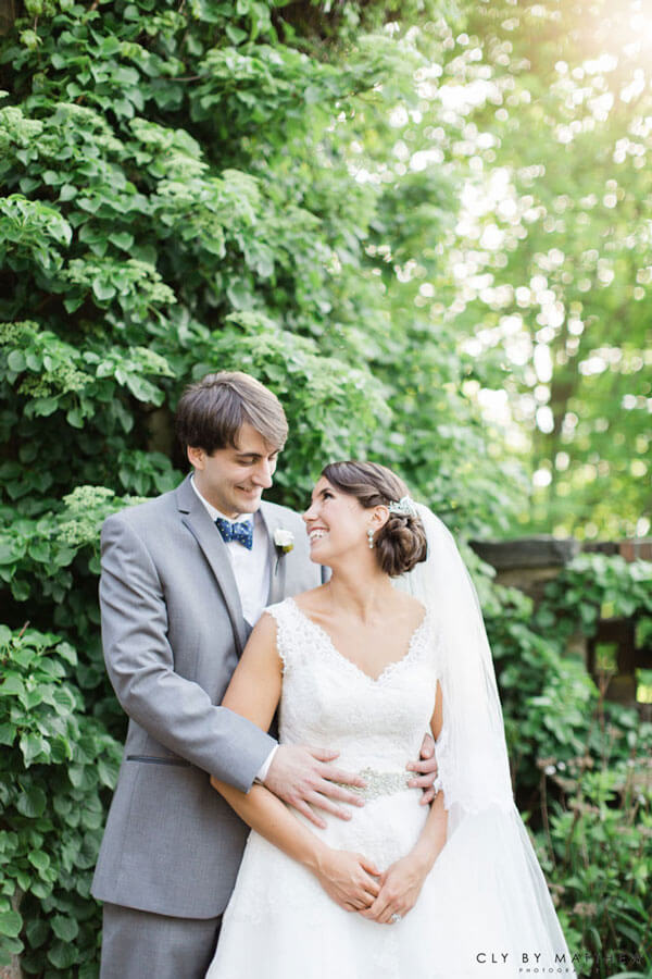 Bride and groom embracing in lush garden at Le Chateau wedding venue