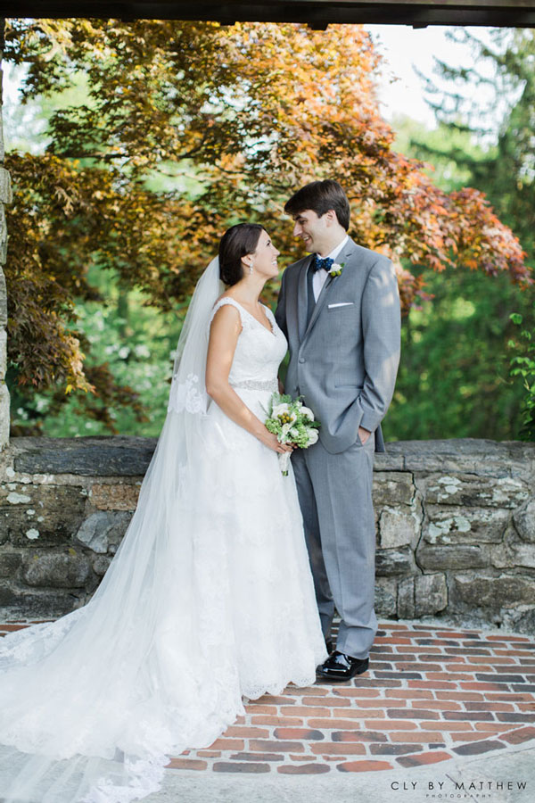 Bride and groom posing for wedding portraits at an outdoor banquet venue.