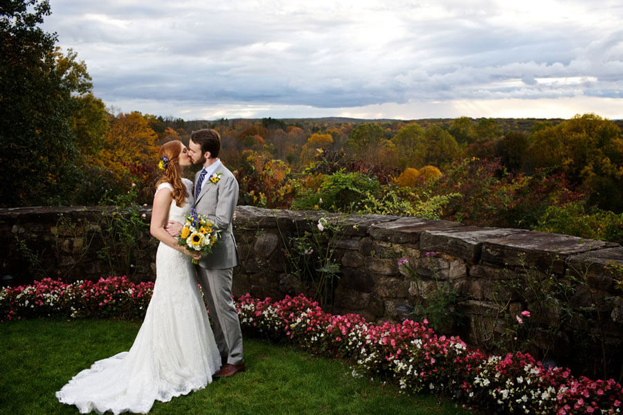 Bride and groom sharing a kiss with scenic garden views at Le Chateau Banquets grounds