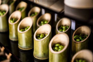 Asian station appetizer display with edamame served in elegant bamboo vessels.
