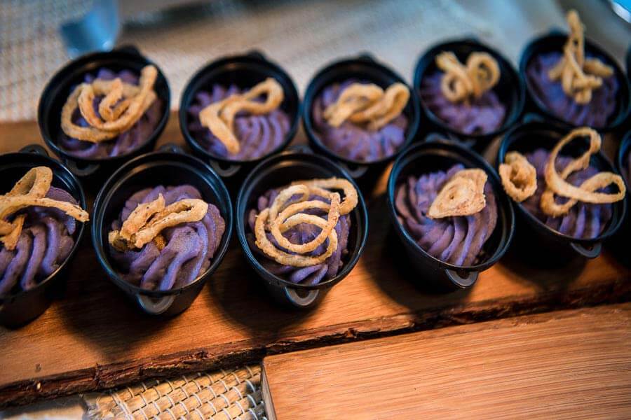 Spud bar appetizer cups with purple mashed potatoes and crispy onion toppings.