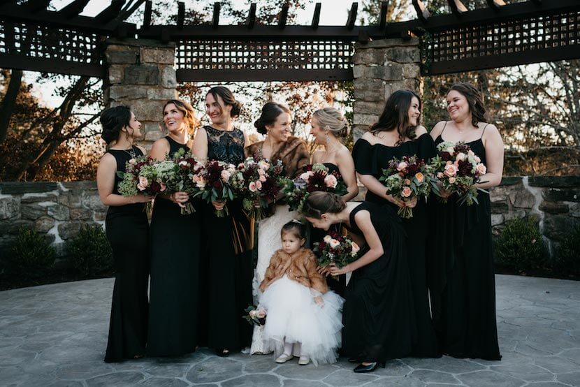 Bridal party posing outdoors with bouquets at Le Chateau wedding venue