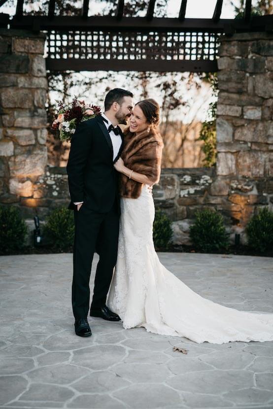 Bride and groom sharing a joyful moment in an outdoor wedding ceremony setting