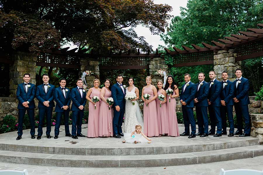 Wedding party gathered for a formal outdoor portrait at a scenic wedding venue.