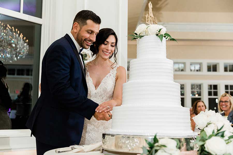Bride and groom cutting elegant wedding cake at Le Chateau reception venue