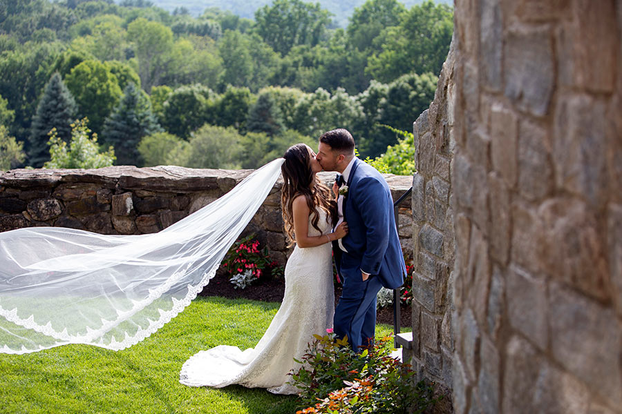 Bride and groom sharing outdoor wedding kiss at Le Chateau garden venue