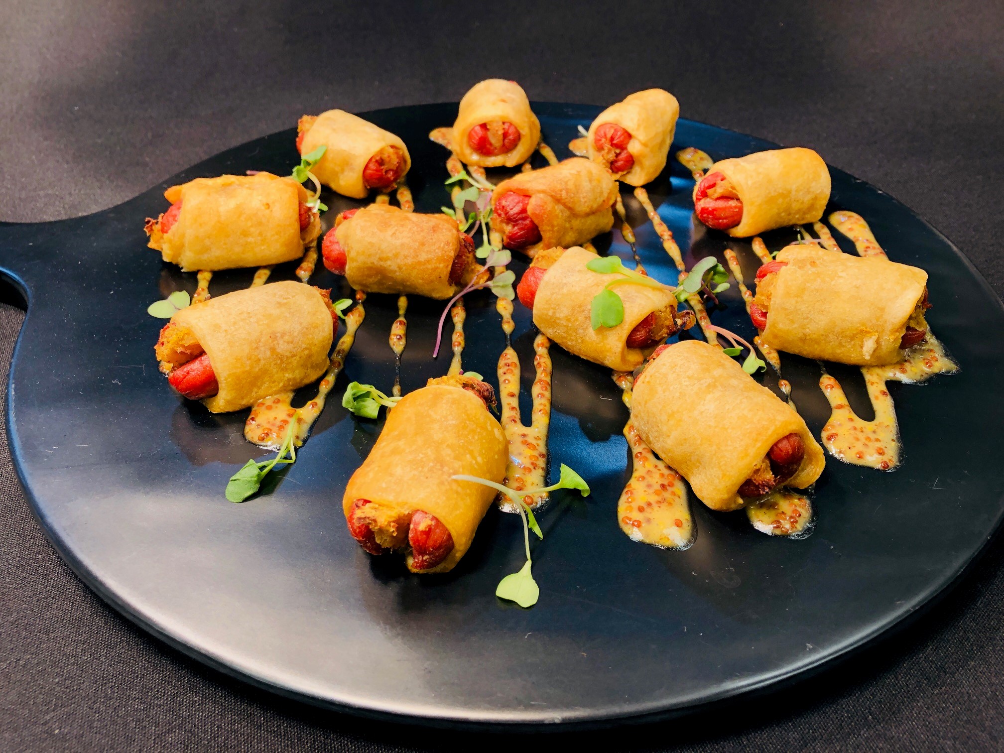 Coney Island-style pigs in a blanket with gourmet mustard drizzle at Le Chateau Banquets