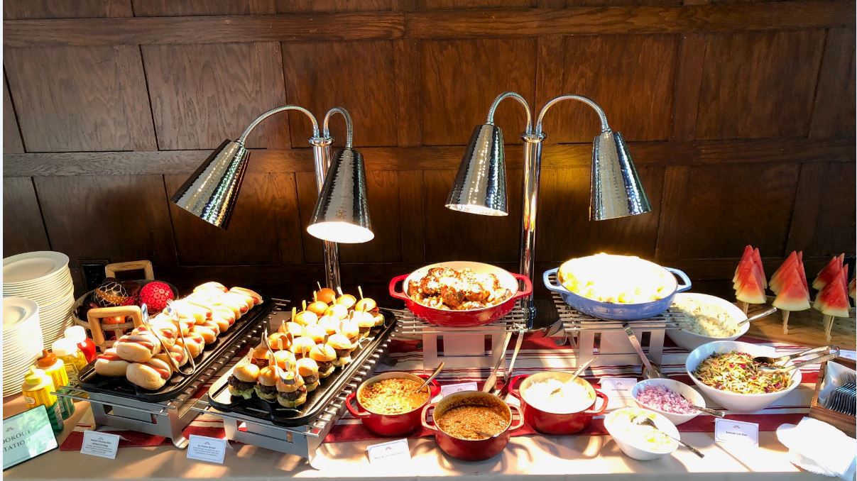 Cookout station with gourmet sliders, barbecue favorites, and fresh summer sides.
