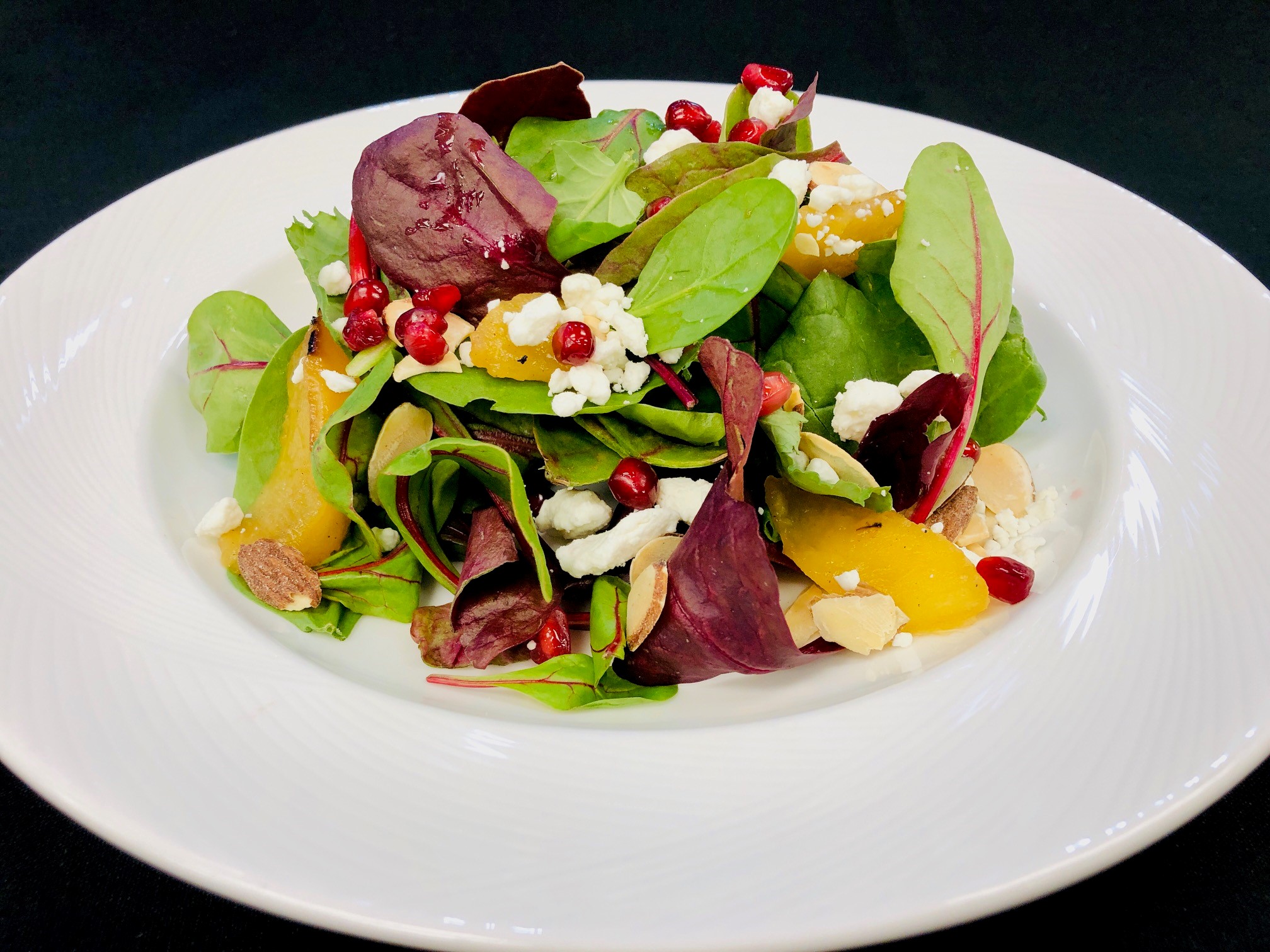 Tri-color kale and Belgian endive salad with pomegranate and citrus garnish