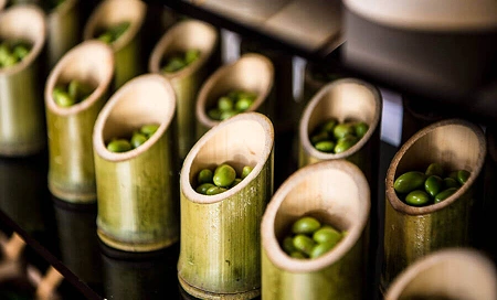 Bamboo cups filled with edamame, elegantly displayed as a unique appetizer presentation.