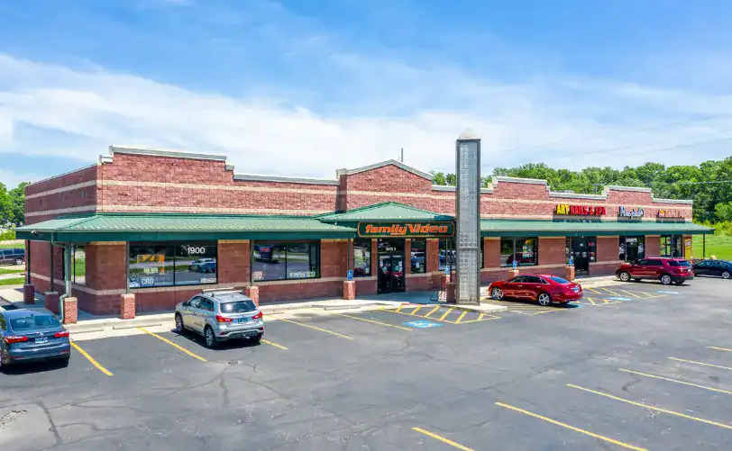Exterior view of a Family Dollar store in a shopping plaza with parking lot and cars.