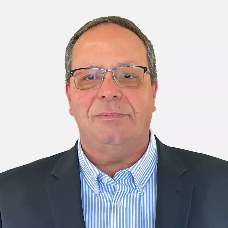 A professional man wearing glasses and a suit, smiling slightly against a plain white background.