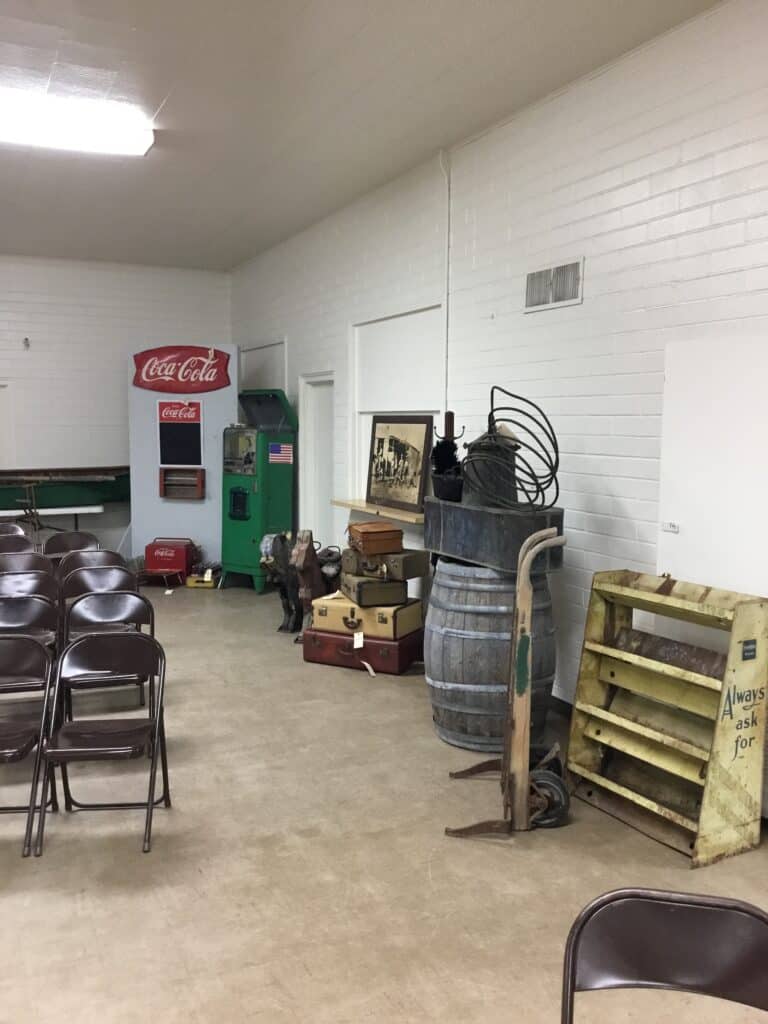 Interior view of Garrett Realty & Auction with chairs, vending machines, and auction supplies.