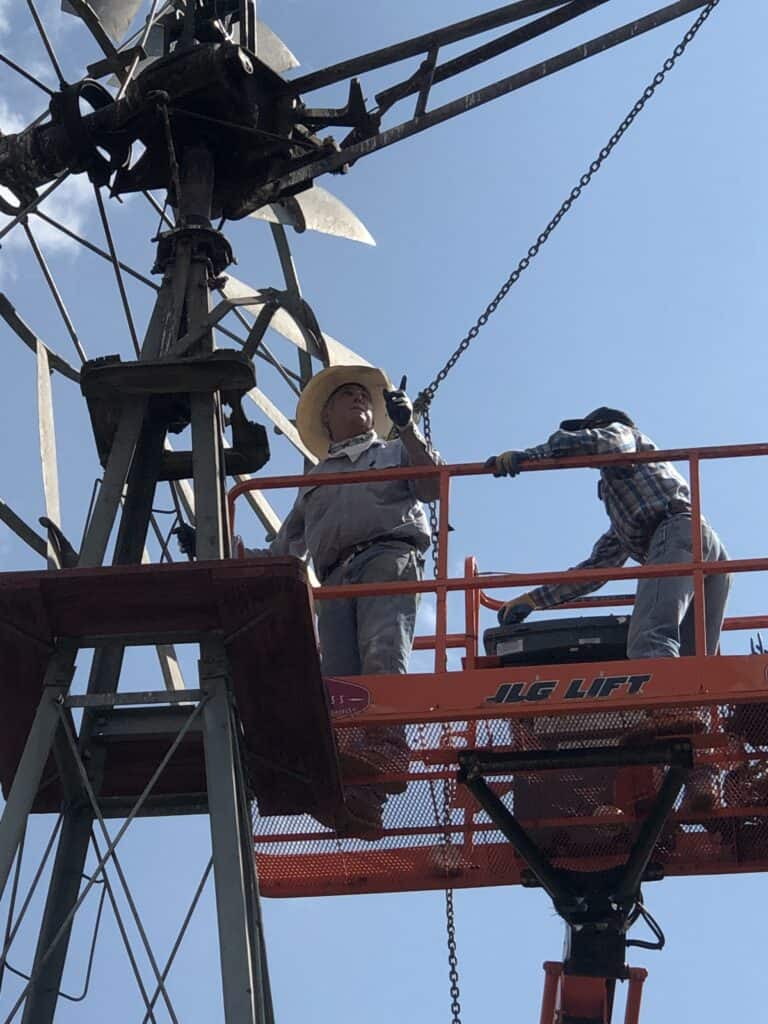 Technicians inspecting high-voltage power lines from a lift platform.