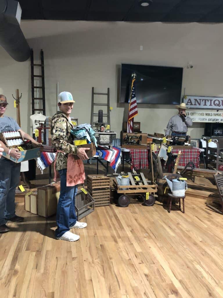 People browsing antique items at Garrett Realty & Auction's vintage market event.