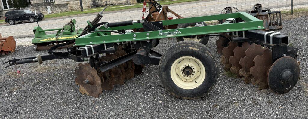 Green disc harrow for farming equipment at auction.