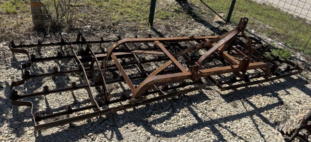 Farm equipment frame, rusted metal, outdoor display, agricultural machinery, Garrett Realty & Auctio.