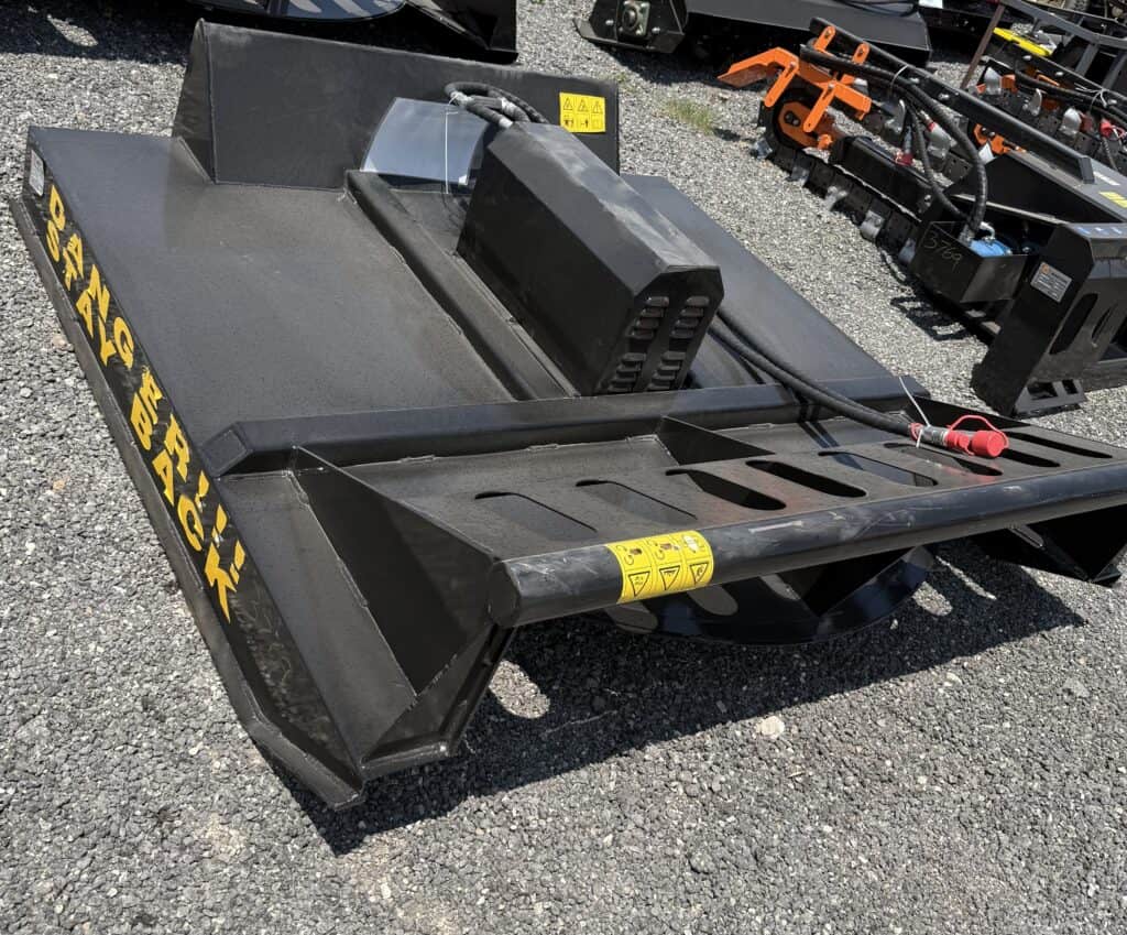 Heavy-duty skid steer loader attachment displayed outdoors at Garrett Realty & Auction.
