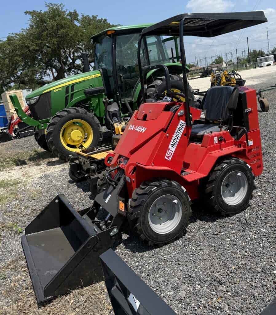 Industrial mini loader with bucket attachment for construction and landscaping projects.