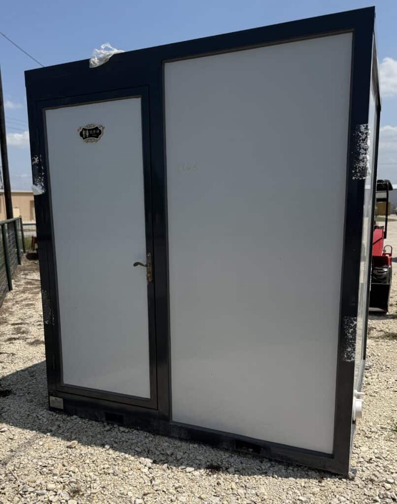 Garage storage shed with black frame and white doors at Garrett Realty & Auction.
