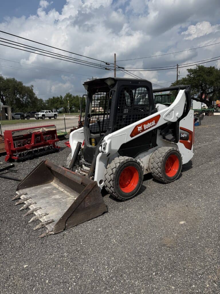 Mini skid steer loader with bucket attachment, ideal for construction and landscaping projects.