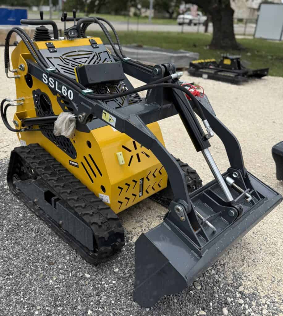 Compact mini excavator with tracked wheels and hydraulic arm for construction or landscaping project.