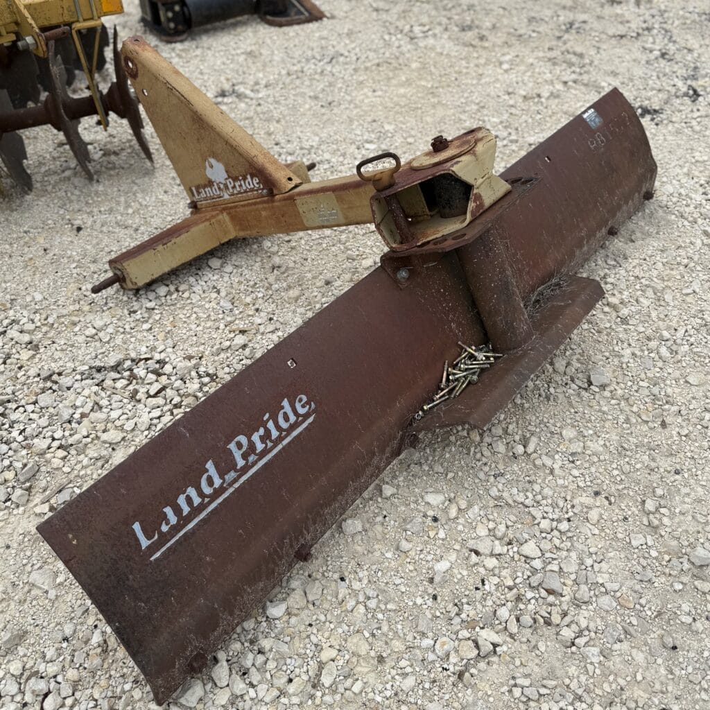 Heavy-duty Land Pride rotary cutter on gravel surface, ideal for farm or landscaping use.