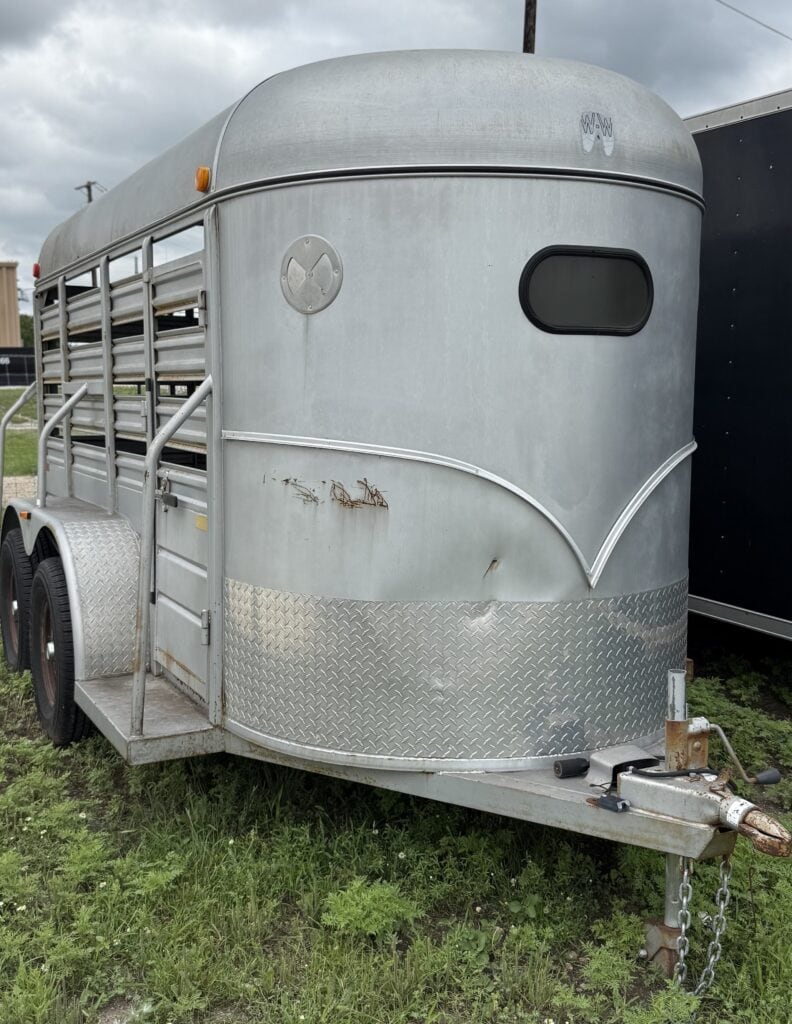 Horse trailer with aluminum build, side ramp, and safety features for equine transport.