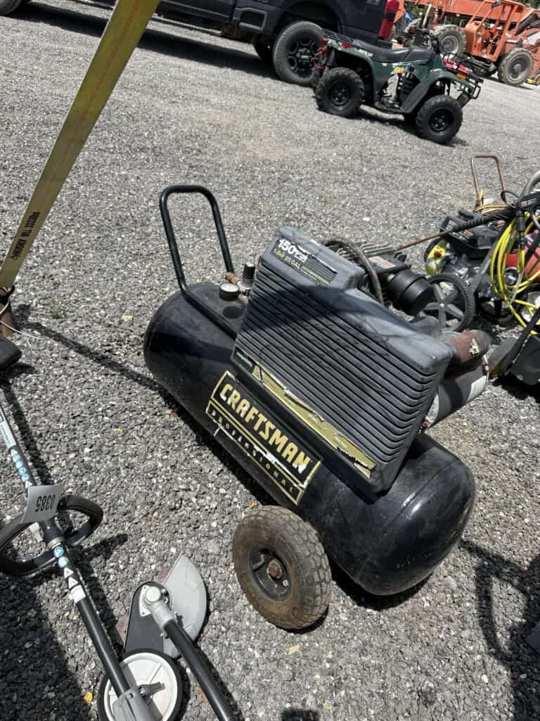Portable Craftsman air compressor for industrial and construction use at auction event.