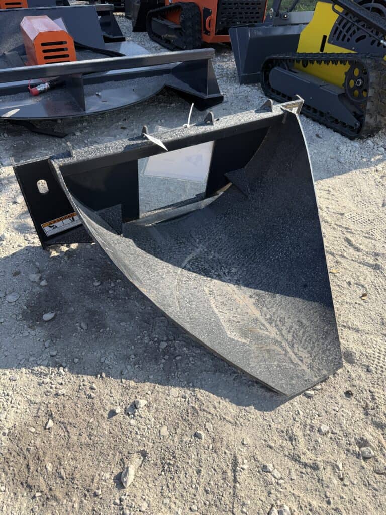 Large black heavy equipment bucket for construction or landscaping.