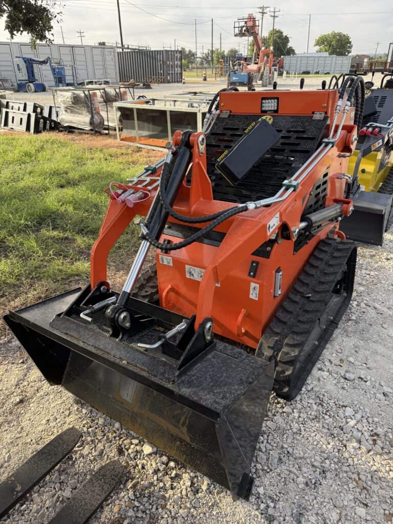 Orange mini skid steer loader at equipment auction site.