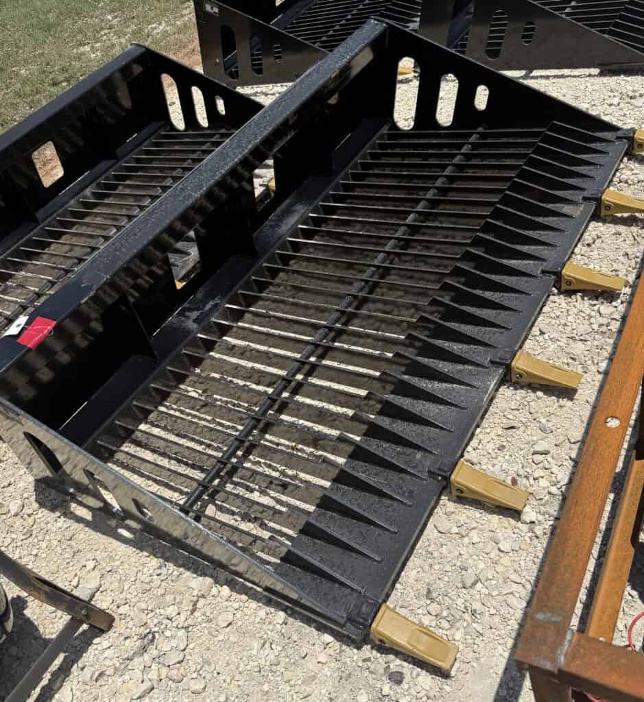 Heavy duty metal rake with wide tines for landscaping and construction work.