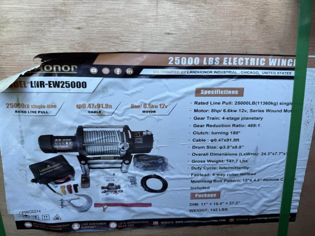 Heavy-duty 25000 lb electric winch with remote control and accessories.