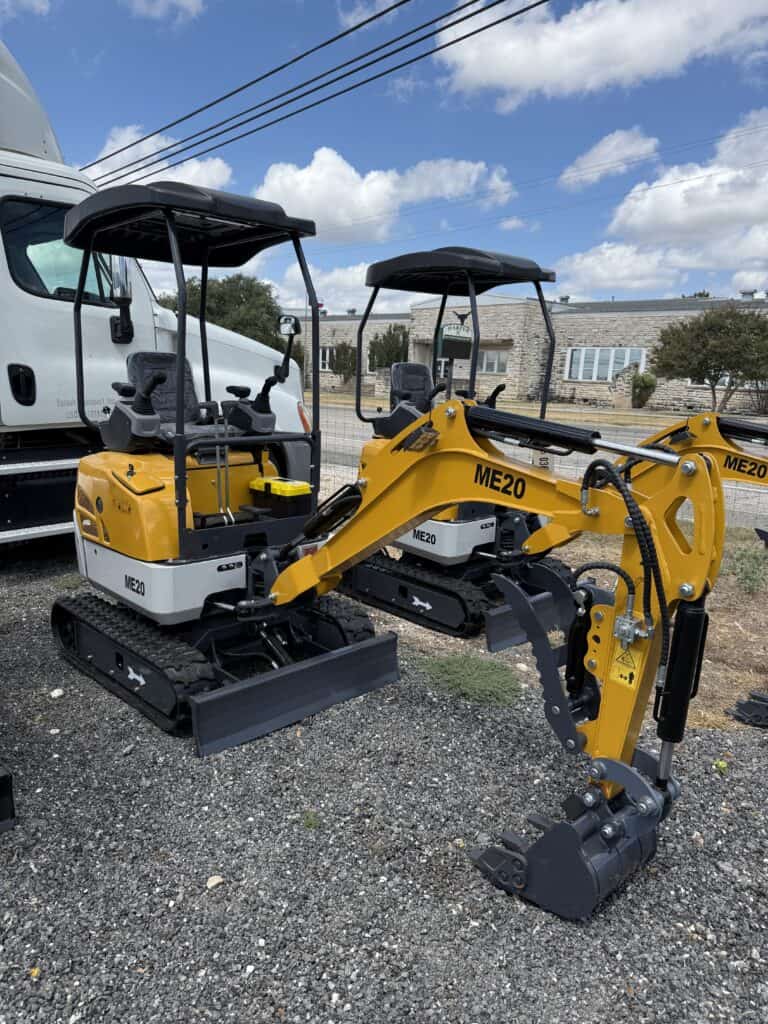 Two yellow mini excavators with black tracks at auction lot.