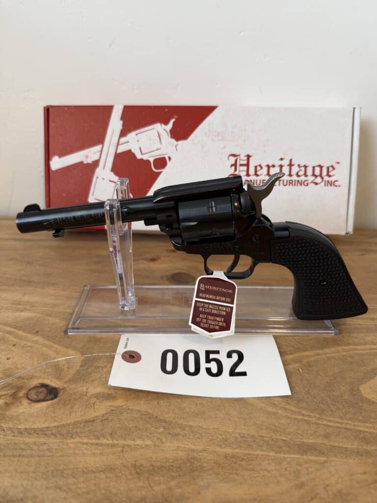 Heritage Manufacturing revolver displayed on auction table with box in background.